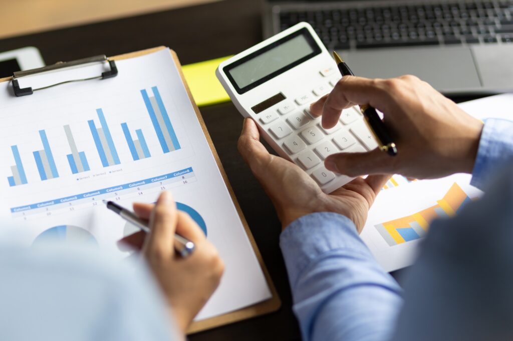 Accountant in the office doing calculations with a calculator.