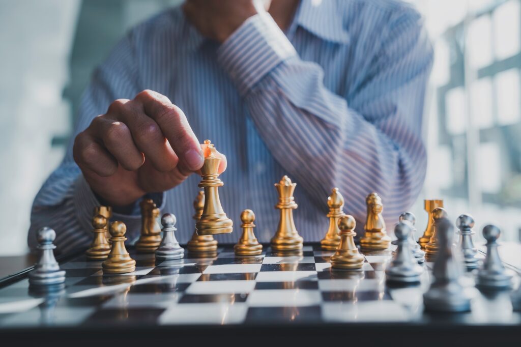 Businessman playing chess game reaching to plan a strategy for success, thinking for planning overco