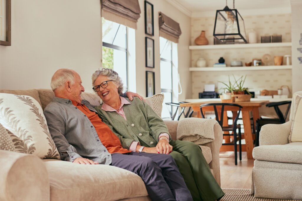 Retired couple embracing and talking while smiling