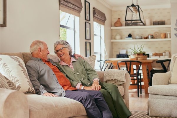 Retired couple embracing and talking while smiling